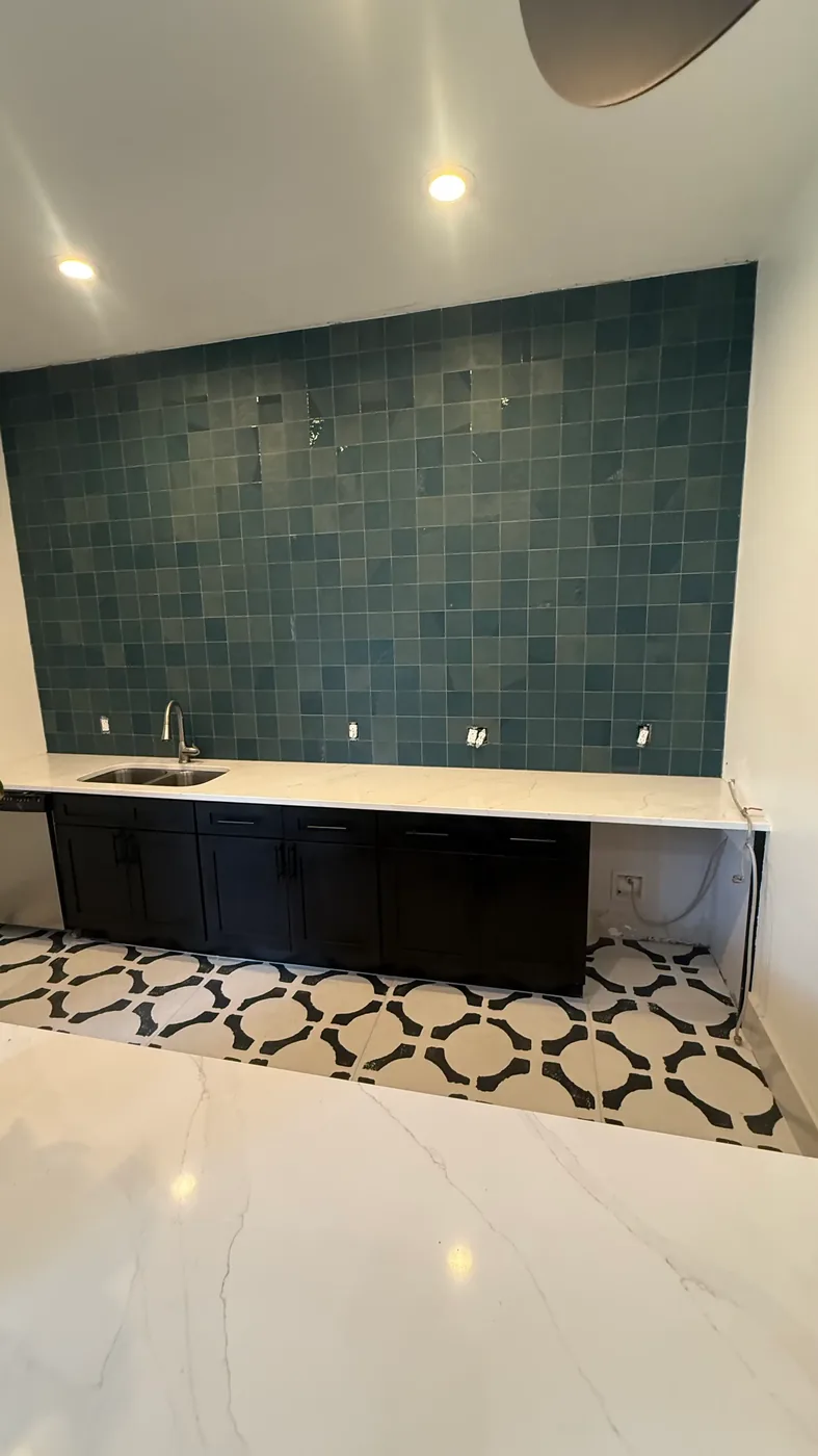 Patterned floor tile leading to a wet bar with framed art in a Chapel Hill commercial space