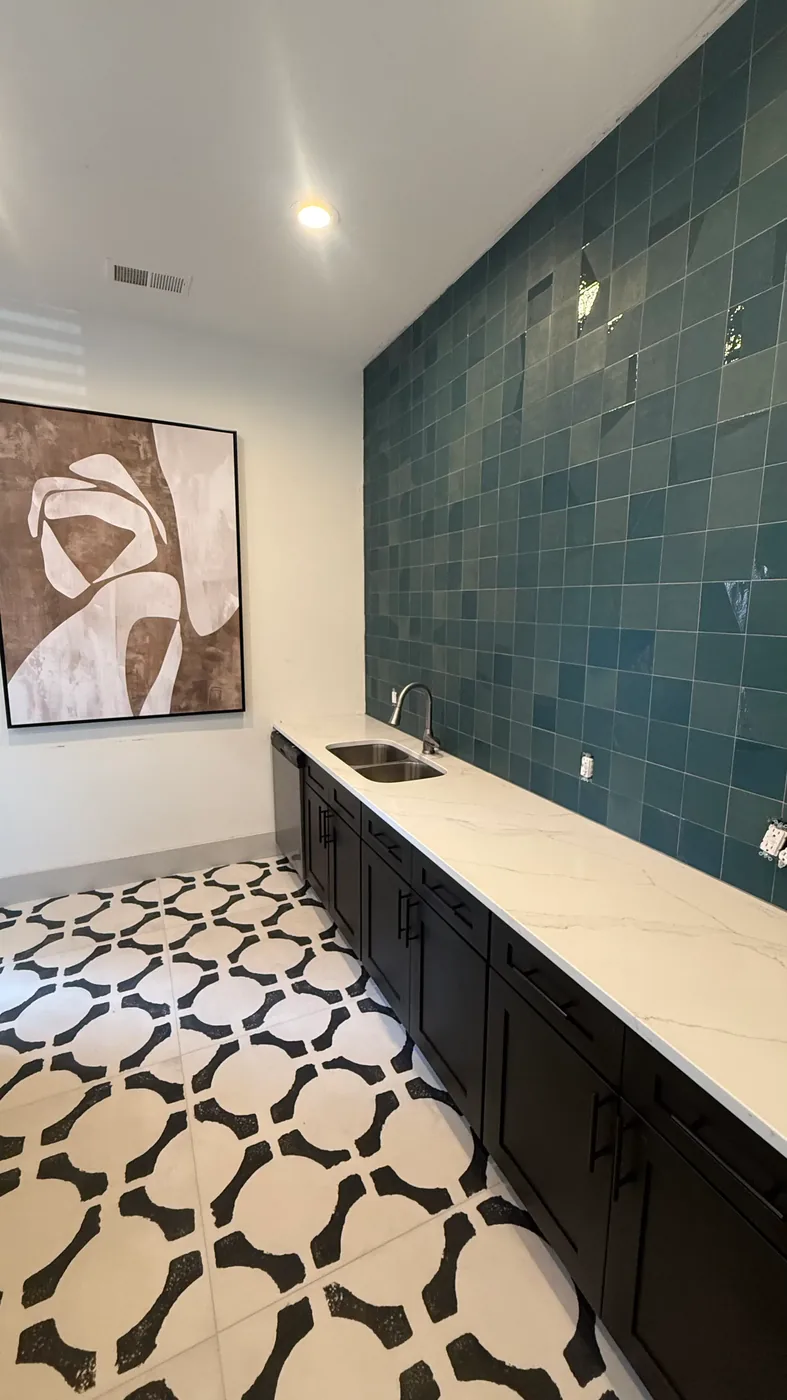 Teal tile backsplash and marble-look counter in a Chapel Hill clubhouse wet bar